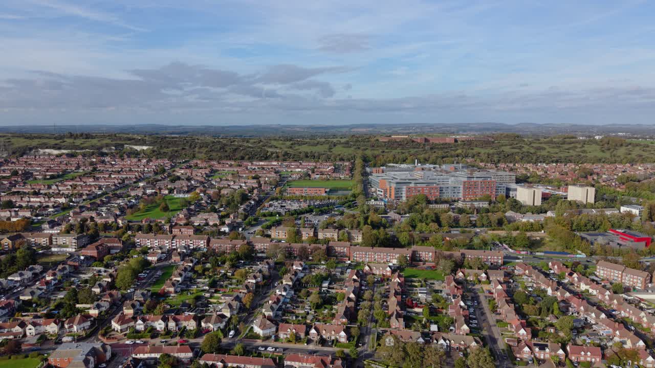 Portsmouth, Regno Unito, riprese in avanti con drone sopra case a schiera e un edificio per uffici, volando verso l'interno in una giornata luminosa e soleggiata. Vista urbana dettagliata