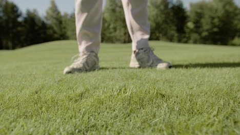 Unrecognizable-person-hitting-golf-ball-in-grass-field