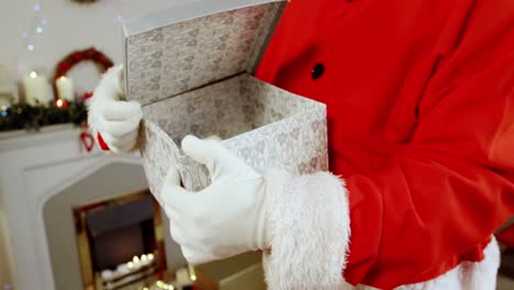 Mid-section-of-santa-claus-holding-gift-box