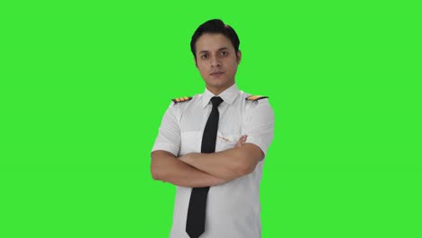 portrait of indian male pilot standing crossed hands green screen