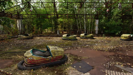 abandoned and rusty bump cars in pripyat amusement park, zoom out view