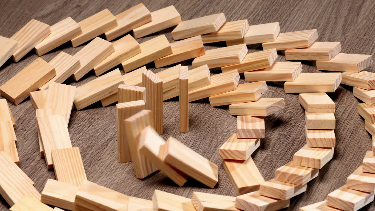 Concetto dell'effetto domino circolare, domino in legno che cadono in una reazione a catena circolare, blocco di legno rovesciato in sequenza continua, prevenzione, sviluppo verso la stabilità, strategia aziendale, gestione del rischio