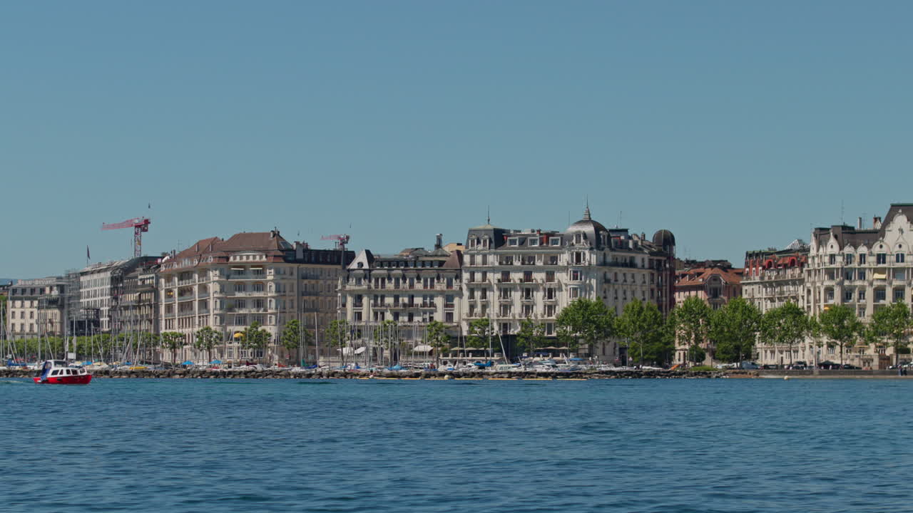 Peaceful morning in Geneva with the iconic Jet d’Eau rising from the lake, calm waters reflecting the clear sky, and the city slowly coming to life in the morning light.