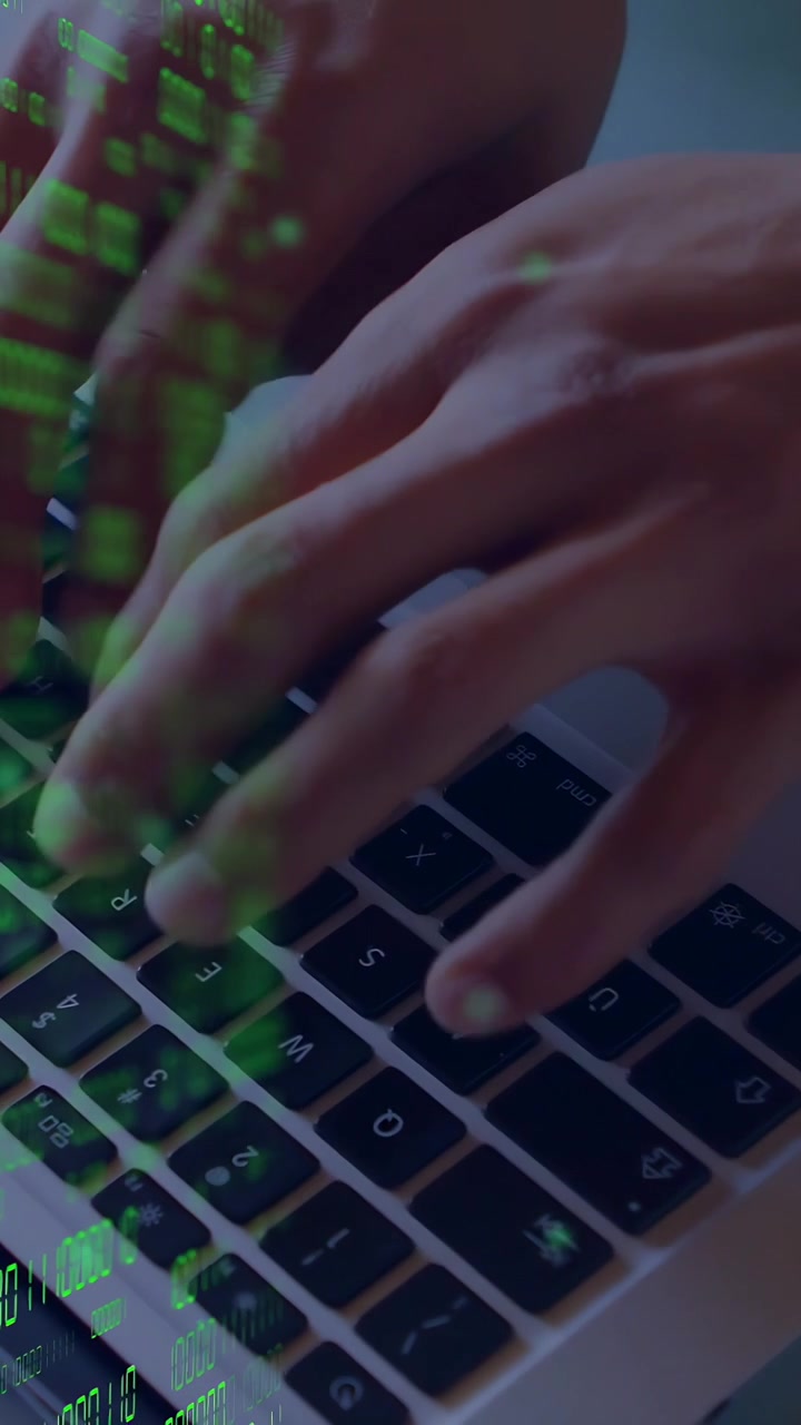 Video verticale: Un uomo digita sulla tastiera e usa il trackpad, creando una sovrapposizione di codice verde mentre modifica il codice.