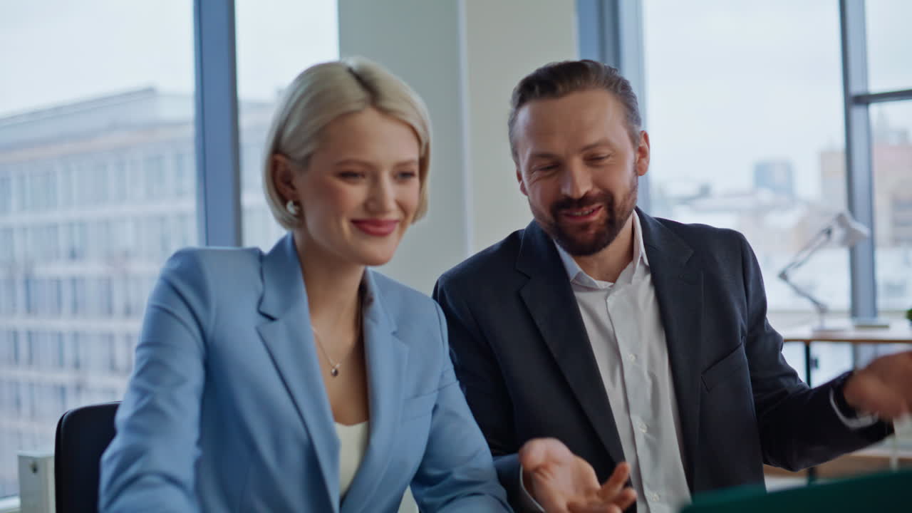 Successful employees chatting online looking laptop at agency office closeup