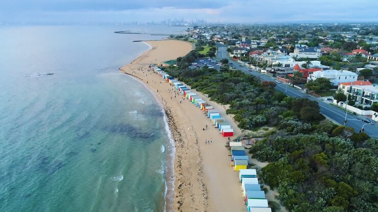 Brighton Beach Boxes quay từ trên không nghiêng lên để lộ Đường chân trời thành phố Melbourne