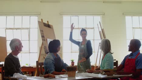 mujer ayudando a artistas en la clase 4k