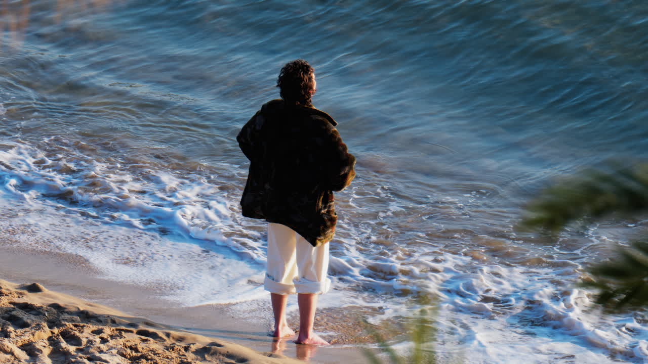 A man with bare feet walking on the beach, near the sea in Cannes, France