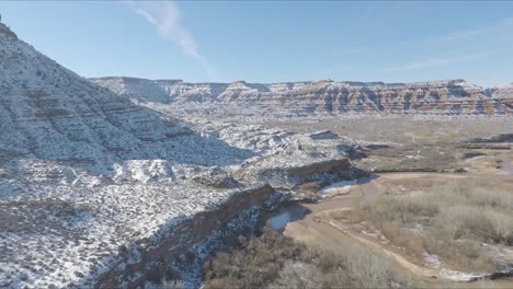 drone flying through zion in utah featuring snow covered mountains on a winters day