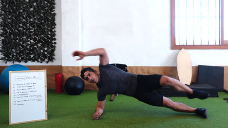 el entrenador hace ejercicio abdominal frente a la cámara mientras explica en clase en línea que hacer desde casa