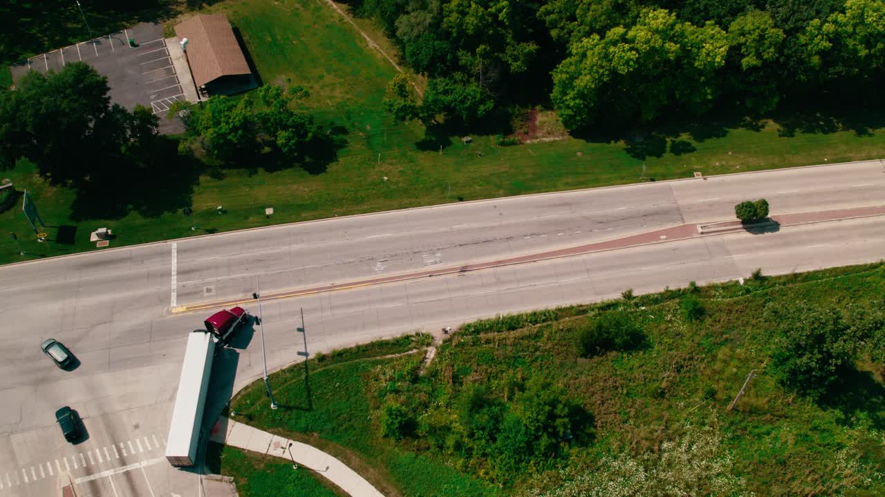 두 개의 빨간색 준 트럭과 트레일러가 빨간색 빛을 멈추고 오른쪽으로 가고 있습니다.
