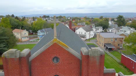 a flock of birds flying by a church cross almost hitting the drone