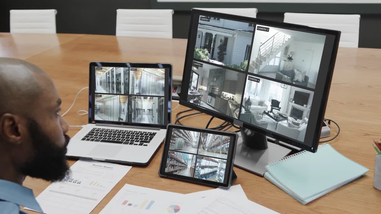 oficial de seguridad afroamericano viendo las vistas de las cámaras de cctv en pantallas de computadora, cámara lenta