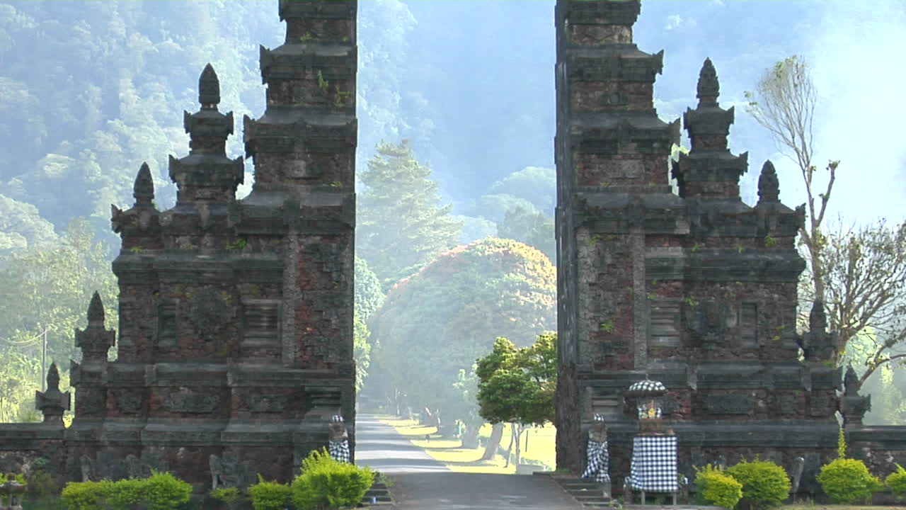 インドネシアのバリ島にある伝統的な寺院の門のそばを霧が漂う
