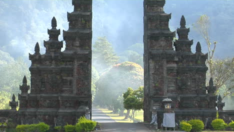 the fog drifts by a traditional balinese temple gate in bali indonesia 3