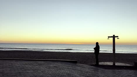 hombre al atardecer, viendo la puesta de sol a lo largo de la costa albanesa del mar adriático