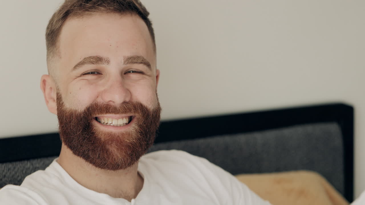 Primo piano di un uomo barbuto sorridente