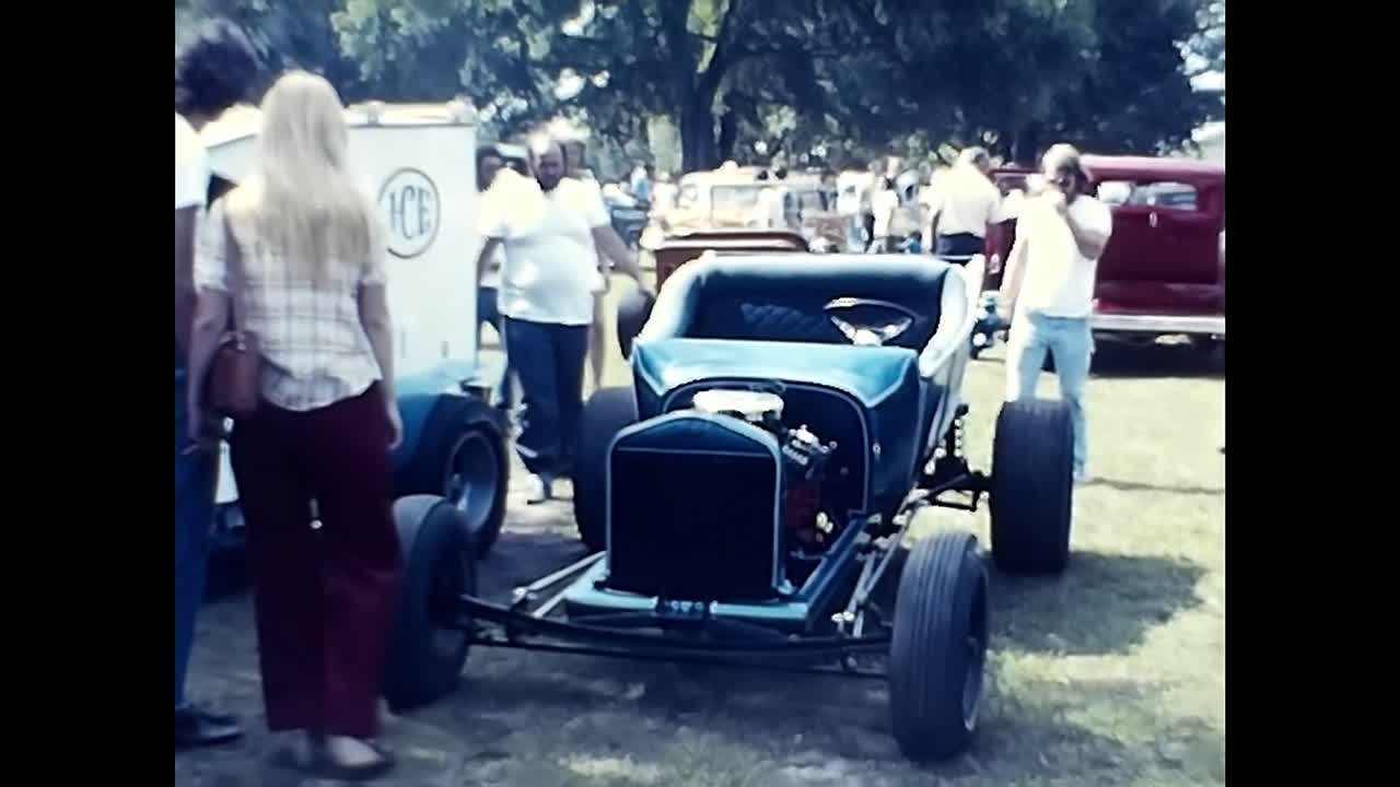 Vintage Car Parked Next to Trailer at 1970s US Old Car Show. CIRCA USA - 1970s: An old car from the 1970s is parked next to a trailer at a vintage car show in the USA.