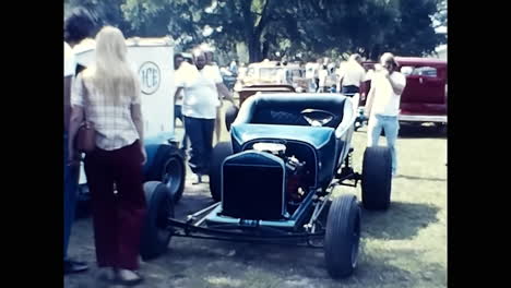 vintage car parked next to trailer at 1970s us old car show. circa usa - 1970s: an old car from the 1970s is parked next to a trailer at a vintage car show in the usa.