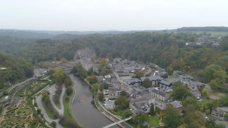 beautiful townscape surrounded by lush green plants and trees in durbuy, luxembourg, belgium - aerial drone shot