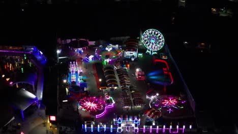 Vibrant view of bustling pop-up festival carnival and amusement park at Catanduanes, Philippines during nighttime - aerial orbit
