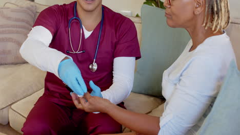 carer in scrubs showing smartphone to elderly woman at home, smiling warmly