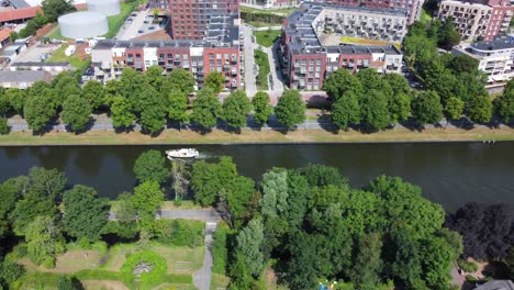 boat travels along canal between trees on either side