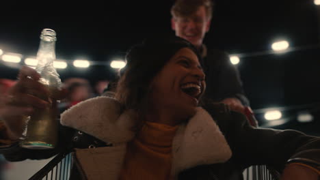 hermosa mujer de raza mixta divirtiéndose sentada en un carrito de compras grupo de amigos disfrutando de una loca fiesta en la azotea por la noche celebrando juguetón el fin de semana bebiendo
