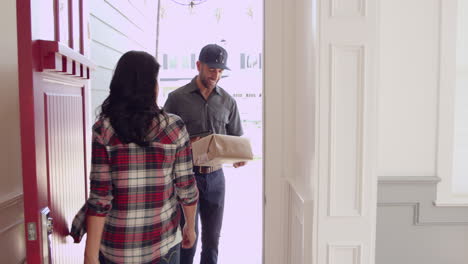 mujer recibiendo un paquete al mensajero en casa filmado en r3d