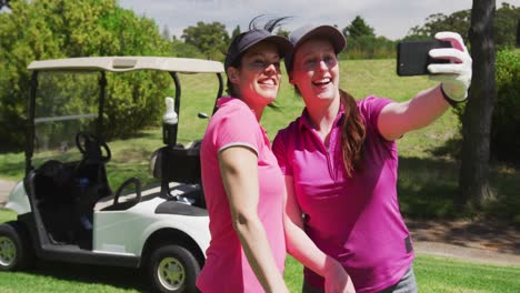 Dos-Mujeres-Caucásicas-Jugando-Golf-Usando-Un-Teléfono-Inteligente-Tomando-Una-Selfie
