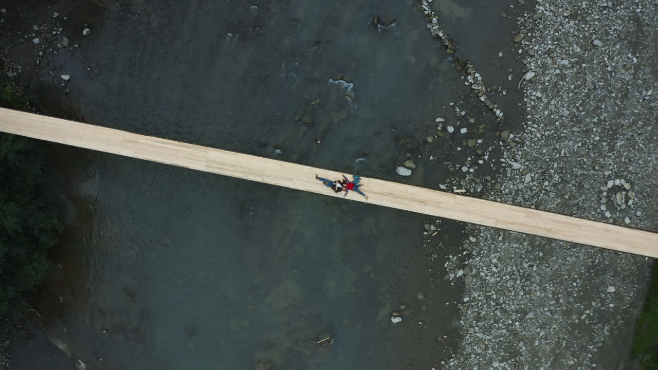 공중 산 다리 커플이 하늘을 즐기고 강을 누워서 휴식을 취하고 활동적인 주말