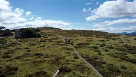 Drone-following-mountain-bikers-along-a-trail-on-top-of-a-mountain-in-the-sunshine