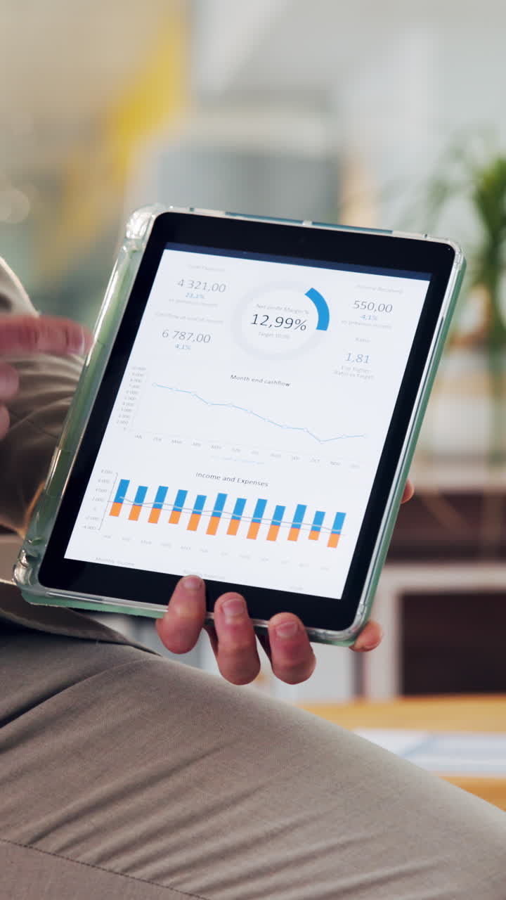Hand Pointing at Financial Data and Charts on Digital Tablet