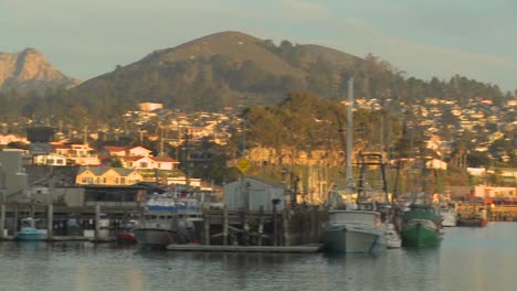 a pan across the small central california town of morro bay with fishing boats in the harbor
