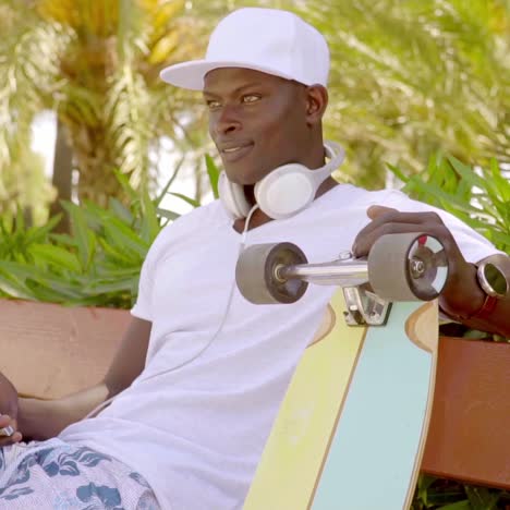 Trendy-young-man-with-a-skateboard-and-mobile