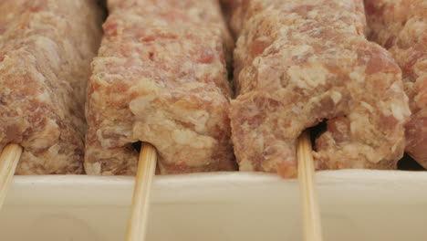 close-up view of uncook mititei on skewers - romanian cuisine