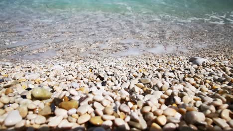 playa con guijarros de colores y olas