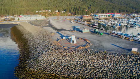 Aerial-360-view-of-Seward-Boat-Harbor,-mountains,-and-downtown-Seward-Alaska-at-sunrise-in-Seward-Alaska