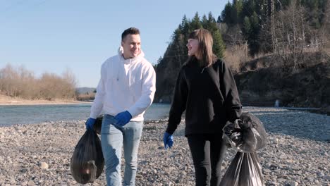 teamwork cleaning plastic on the beach. volunteers collect trash in a trash bag. plastic pollution and environmental problem concept. voluntary cleaning of nature from plastic. greening the planet