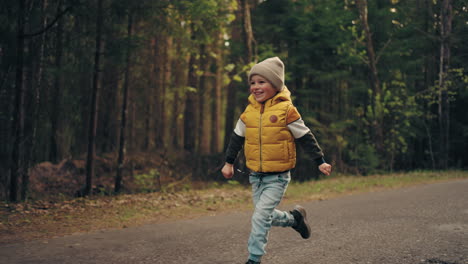 grandad and grandson are going back from fishing cheerful little boy is running over road in woodland area