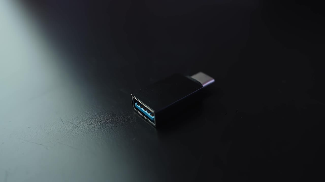 Makro-nærbillede af en USB-A 3.0 til USB-C adapter på et mørkt skrivebord med lav dybdeskarphed og kopiplads, ideel til visuelt indhold om teknologi, forbindelse og enhedskompatibilitet.