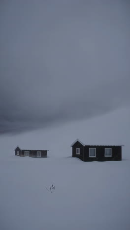 snowy landscape with dark cabins