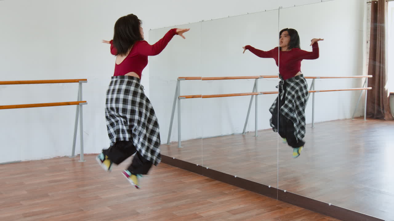A woman practices hip-hop dance in a studio