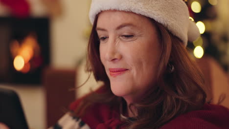 mujer en sombrero de santa mirando el teléfono durante la navidad