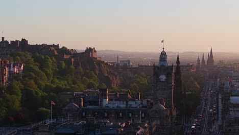 cinematic drone orbit of edinburgh at sunset, showcasing the historic castle, city clock, and majestic buildings bathed in golden light