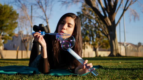 una linda joven que hace burbujas y sonríe con felicidad mientras se divierte al aire libre al atardecer