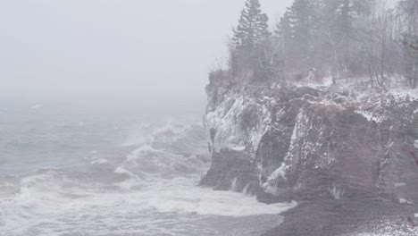 roaring winds and crashing waves on lake superior shoreline. winter storm at tettegouche state park in silver bay, minnesota. wide shot