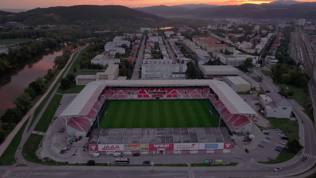 Ripresa aerea dello stadio dell'AS Trencin circondato da città e colline, Slovacchia.