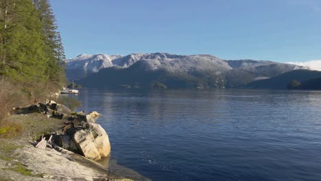 lovely undisturbed nature with green trees, blue water and grey mountains in the background