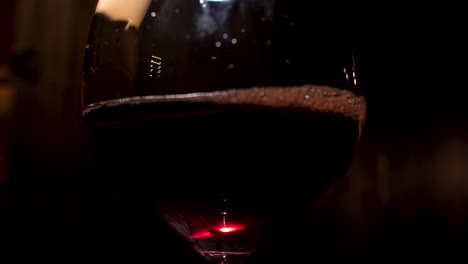 glass of red wine in the dark